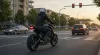 Moto trafegando na cidade com foco em economia de gasolina
