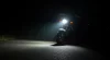 Farol de milha em moto pequena iluminando estrada à noite