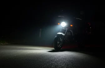Farol de milha em moto pequena iluminando estrada à noite