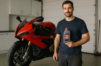 Homem segurando óleo ideal para motos esportivas ao lado de moto vermelha em oficina